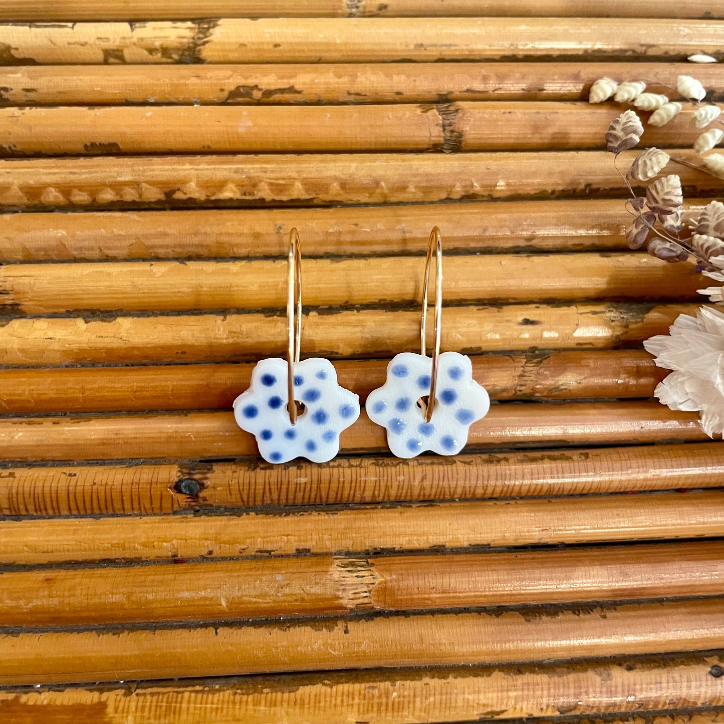 Boucles d'oreilles en céramique fleur blanche et point bleu foncé